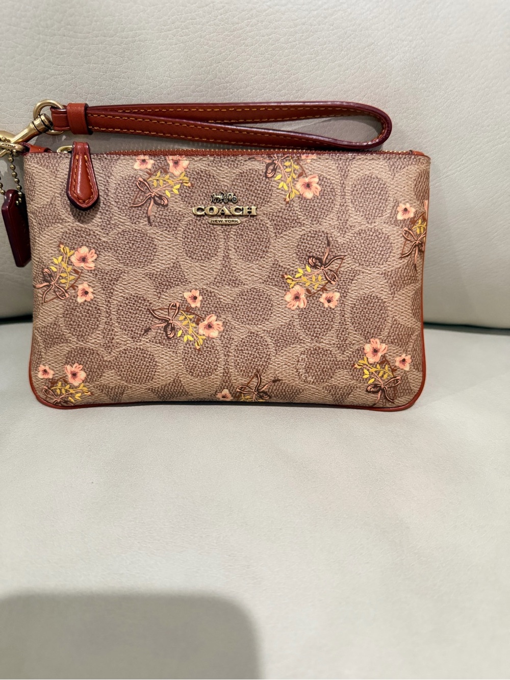 COACH Brown Signature Floral Wristlet with Pink and Yellow Accents